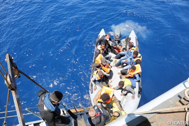 Refugees boarding coastal guard ship