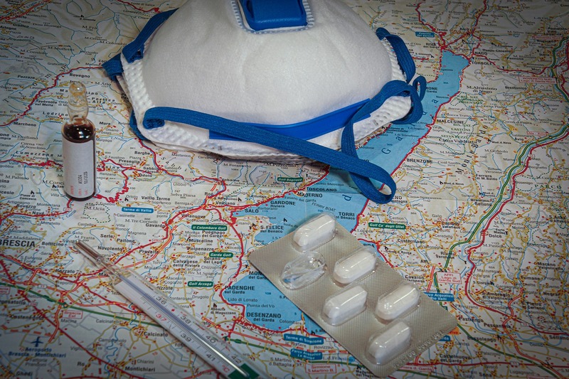 Respirator, termometer and pills on the map